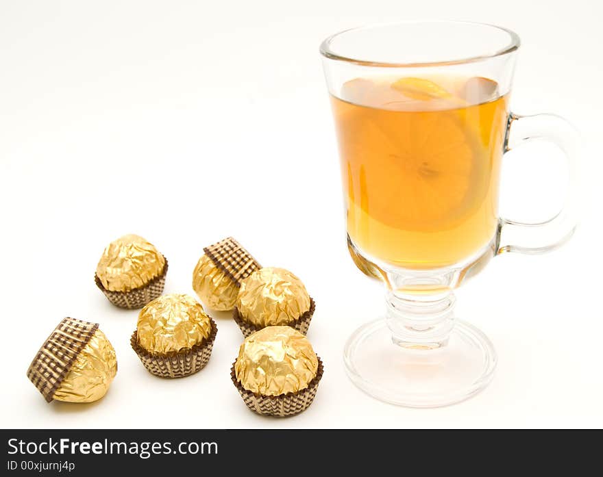 Tea with a lemon in glass chake and candies.