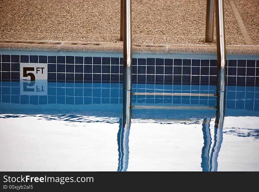 Ladder and sign at the deep end of a swimming pool.