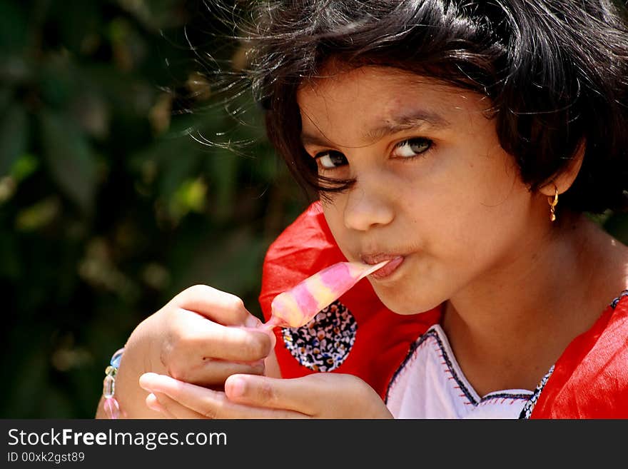 A girl hungrily gulping the ice-cream. A girl hungrily gulping the ice-cream.