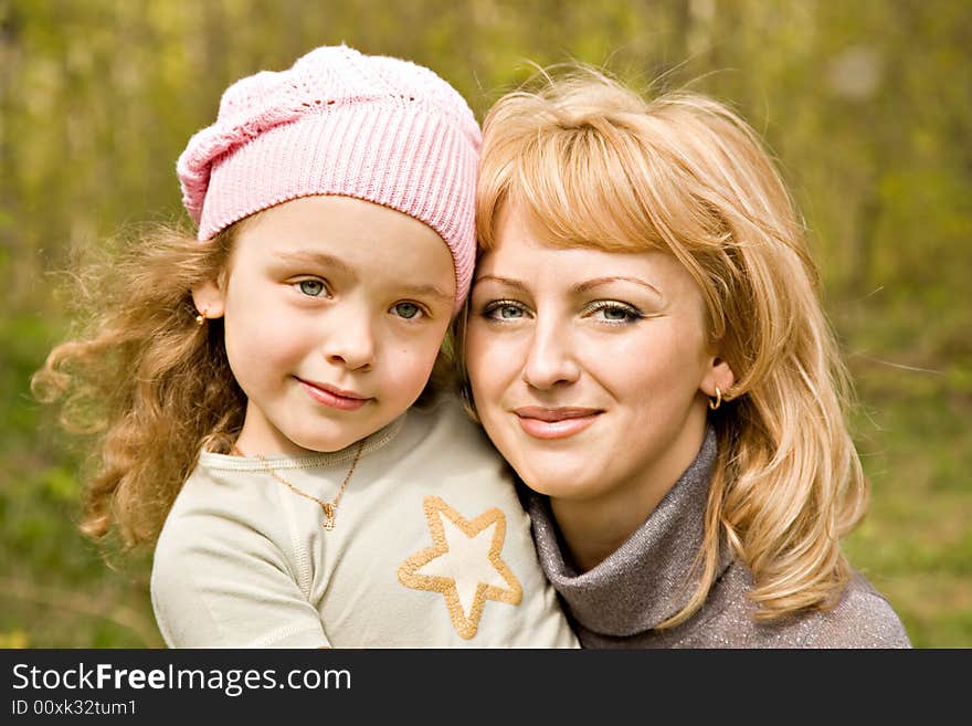 The beautiful little girl in a pink cap with smiling mum with light hair. The beautiful little girl in a pink cap with smiling mum with light hair