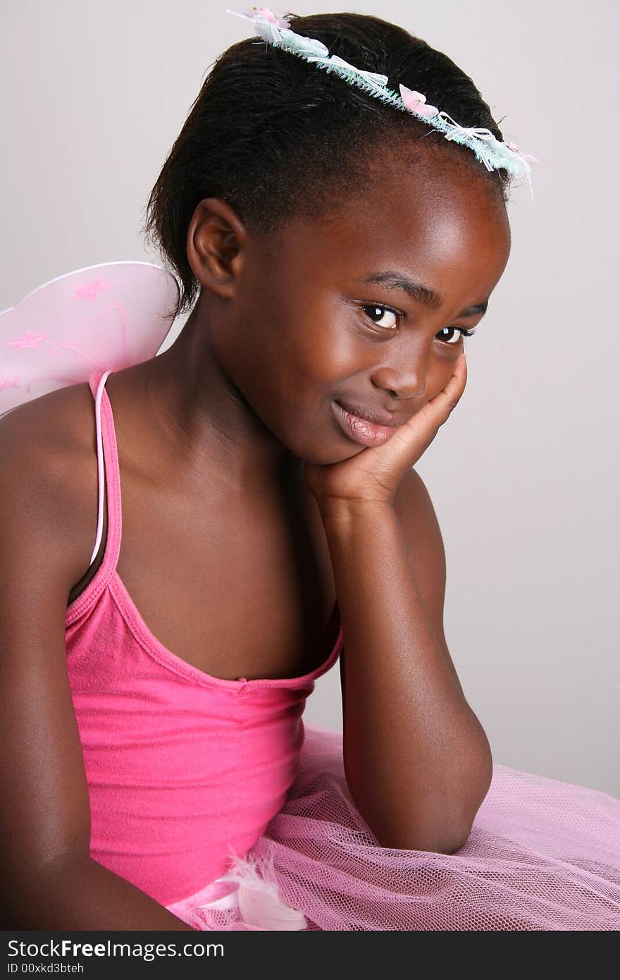 Young girl wearing a pink fairy costume with accessories