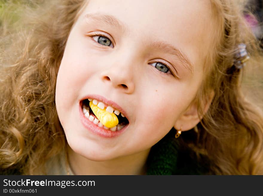 Portrait of the cheerful little girl with a candy. Portrait of the cheerful little girl with a candy