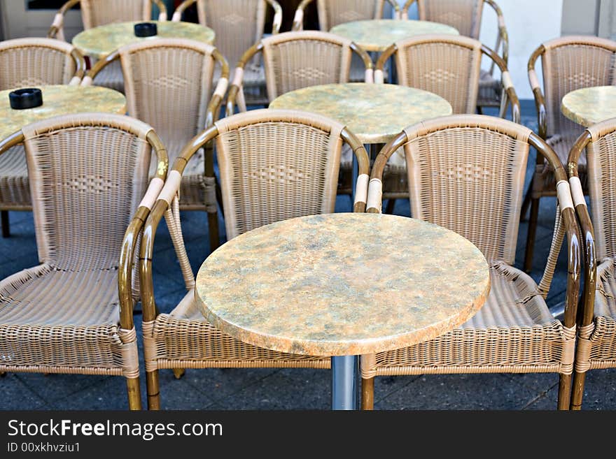 Empty wicker chairs with little tables in a sunny day