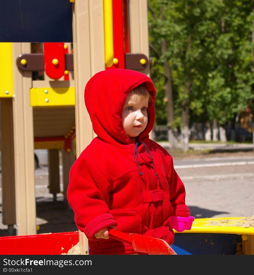 The girl plays sand on a children's playground isolated