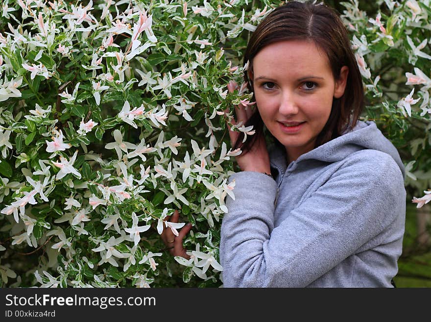 Young woman posing by the flowers. Young woman posing by the flowers