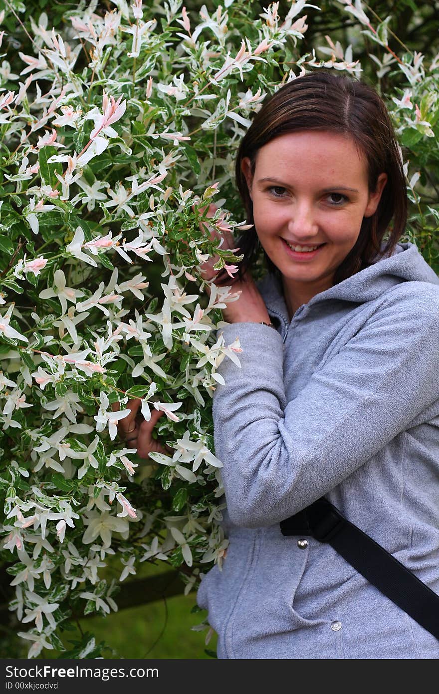 Young woman posing by the flowers. Young woman posing by the flowers