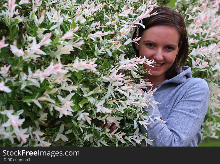 Young woman posing by the flowers. Young woman posing by the flowers