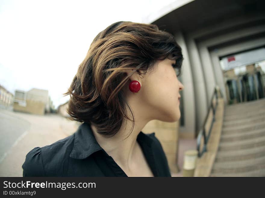 Young lady with red earring in the center of the image. Young lady with red earring in the center of the image