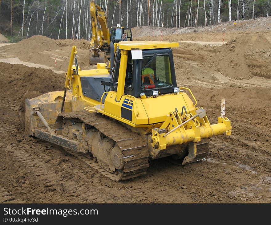 Bulldozer at work with wooden background