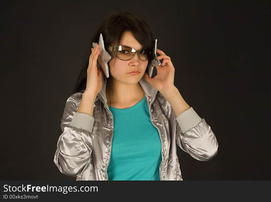 Fashion girl listening to stars isolated on black background