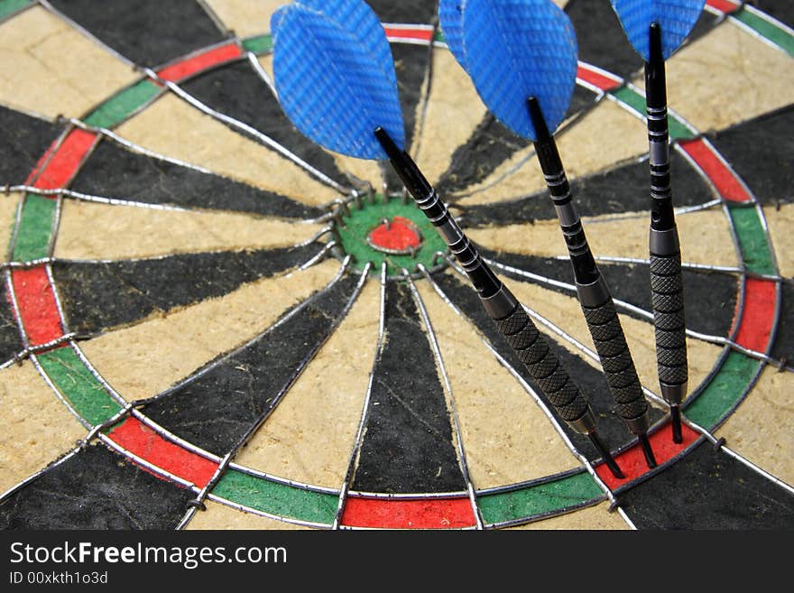 Three darts entire hit dartboard.