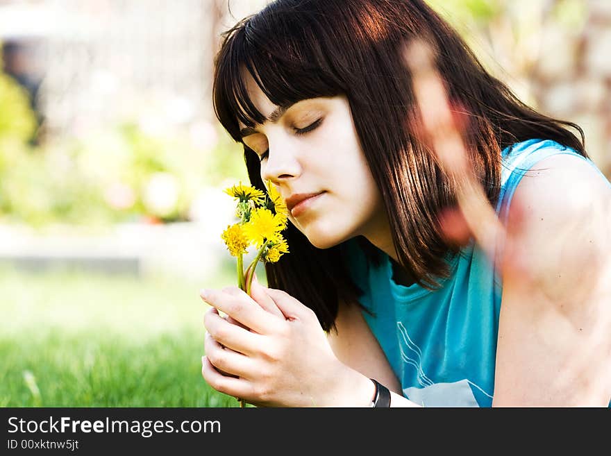 Girl with dandelions lying on the green lawn