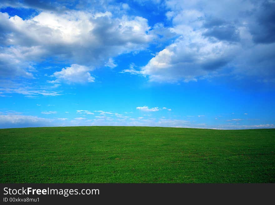 Green field and blue sky with thunder-clouds on it. Green field and blue sky with thunder-clouds on it