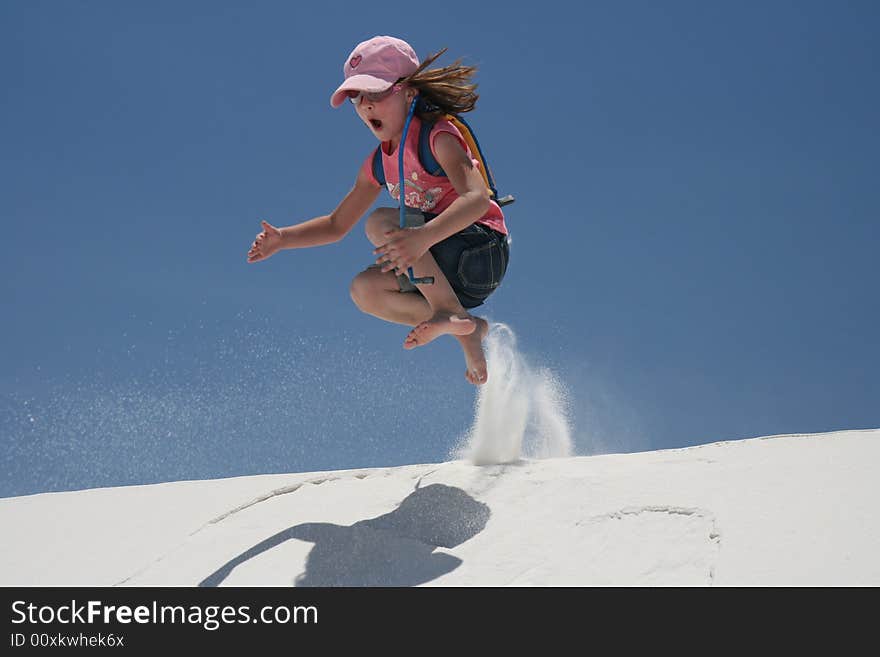 Young child jumping off a sand dune in the desert. Young child jumping off a sand dune in the desert