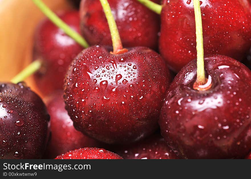 Fresh cherry with drops on background