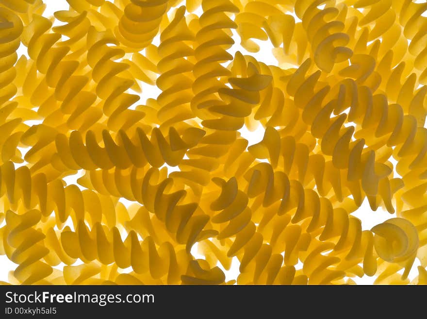 Pieces of fusilli pasta on a lightbed