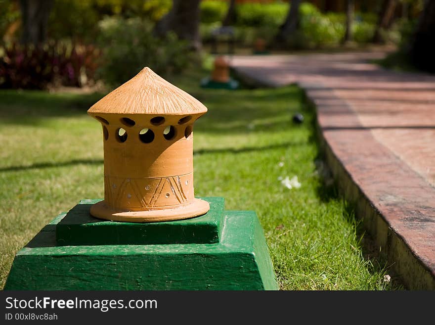 Orange garden lantern near the road in the park.