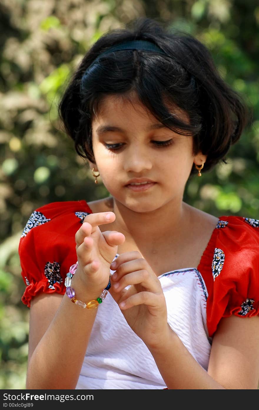 A beautiful Indian girl putting the bracelet in her hand.