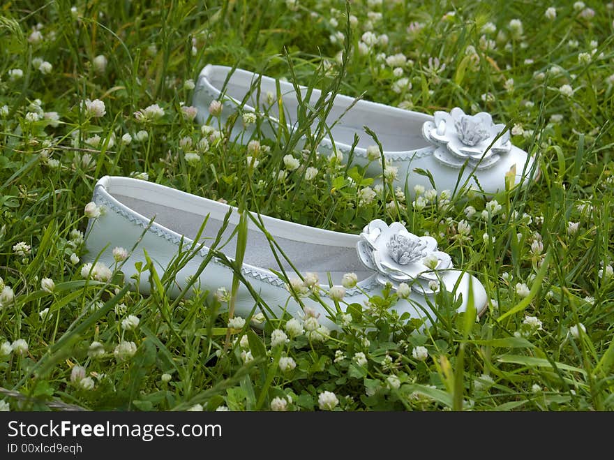 Ceremony white shoes laying on the grass