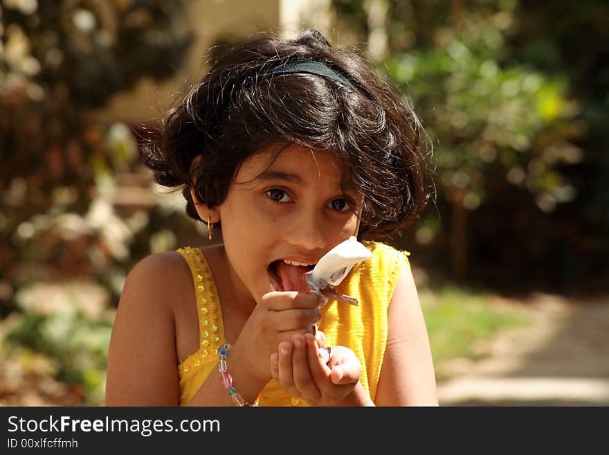 A girl licking the ice-cream candy.