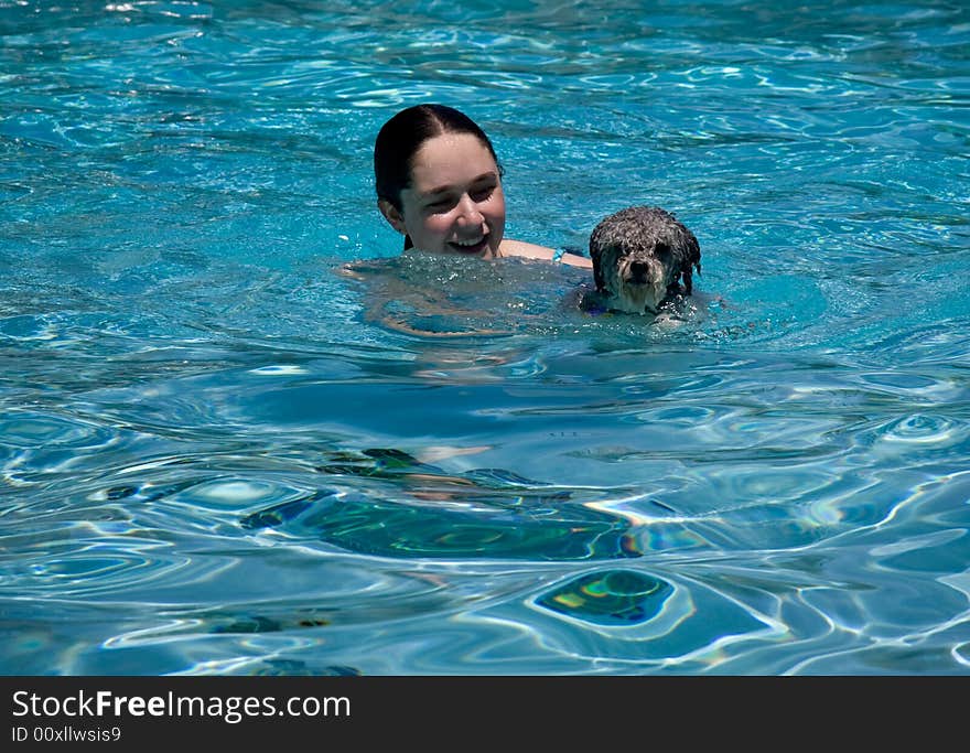 Girl and dog swimming in pool