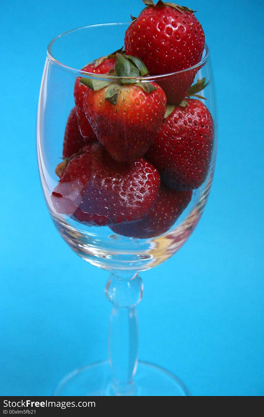 Strawberries in crystal glass with blue background. Strawberries in crystal glass with blue background