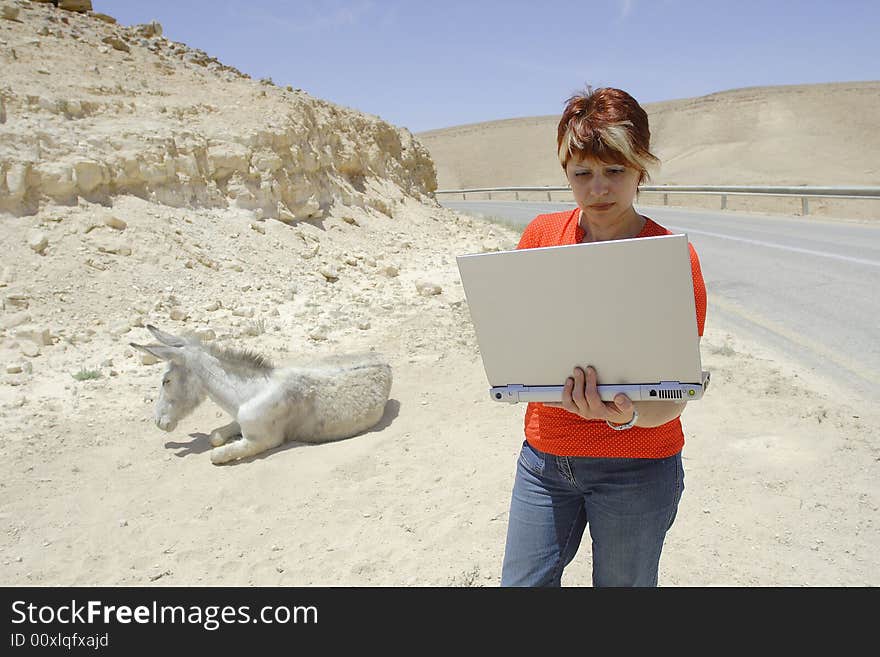 The young woman with a laptop in Judean desert. The young woman with a laptop in Judean desert