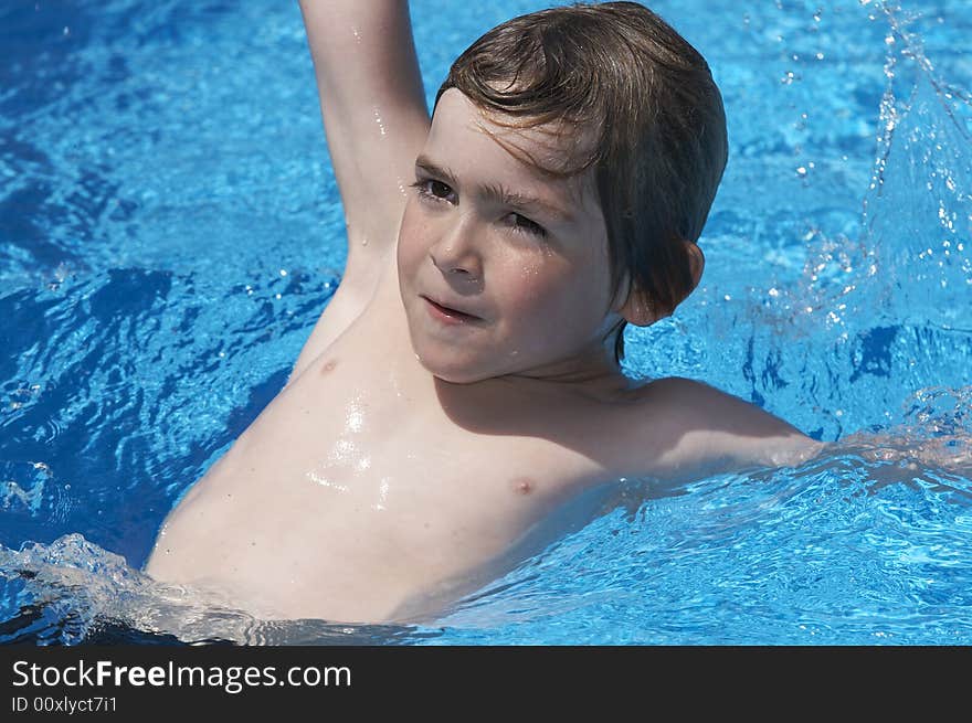 A young boy looking at camera in a pool. A young boy looking at camera in a pool