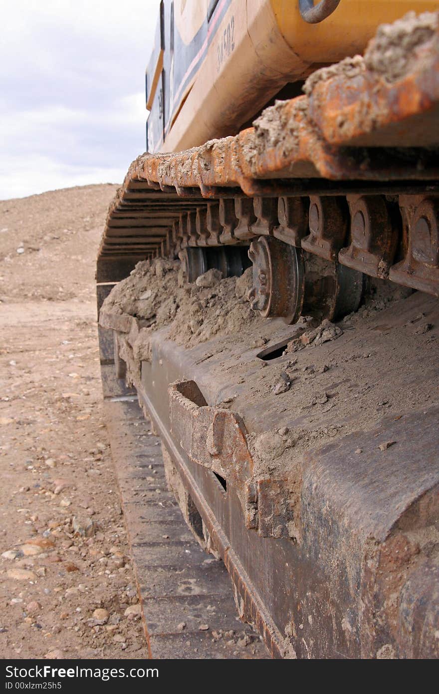 Dried mud and gears on a track belonging to a trackhoe on the job. Dried mud and gears on a track belonging to a trackhoe on the job.