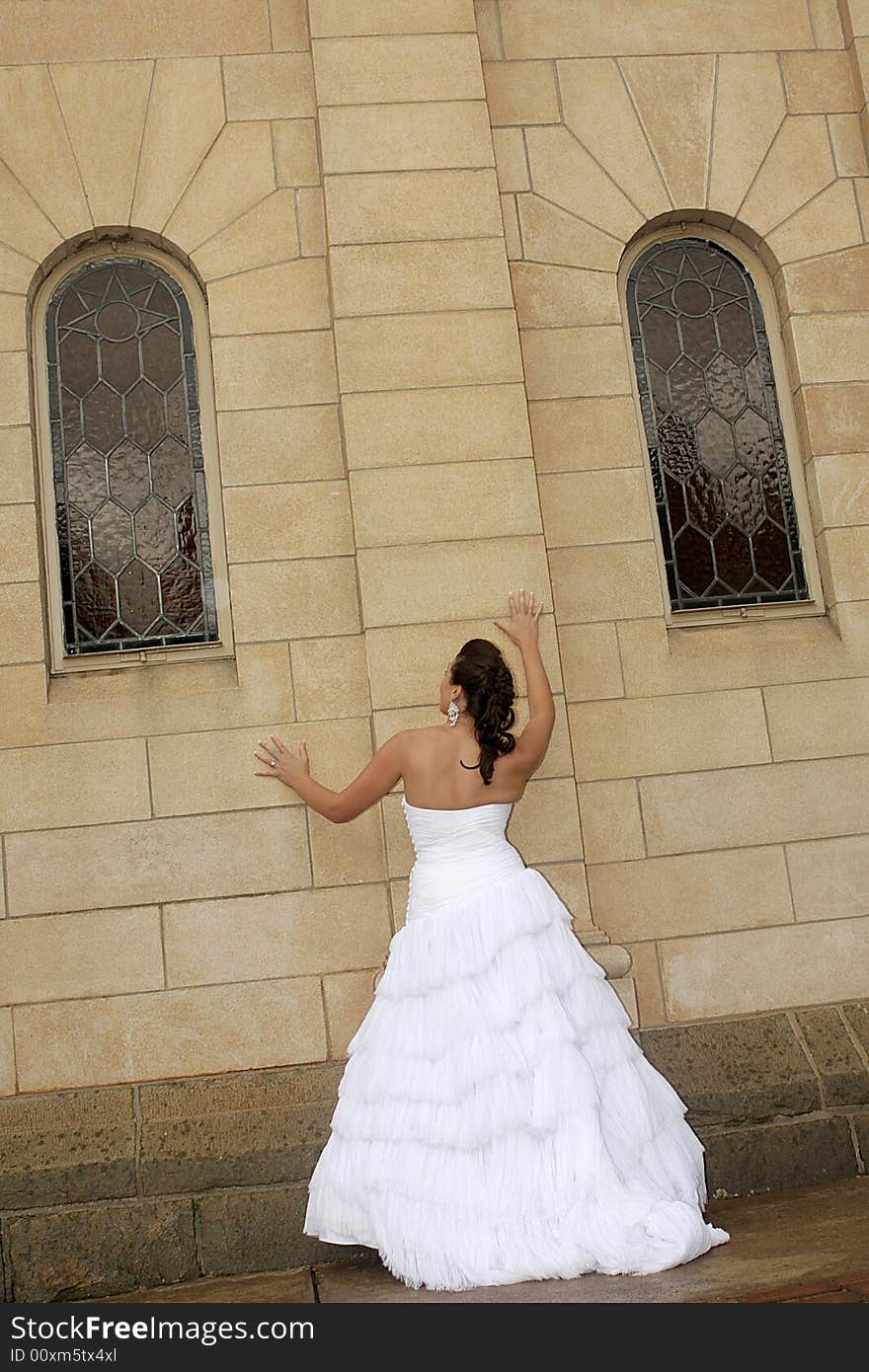 A bride standing next to a chapel. A bride standing next to a chapel