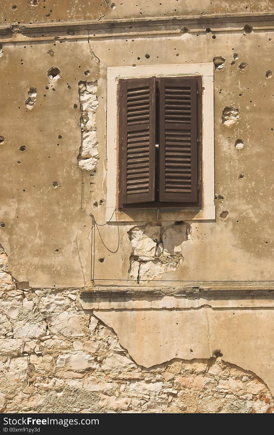 Old building facade in Croatia spotted with bullet holes