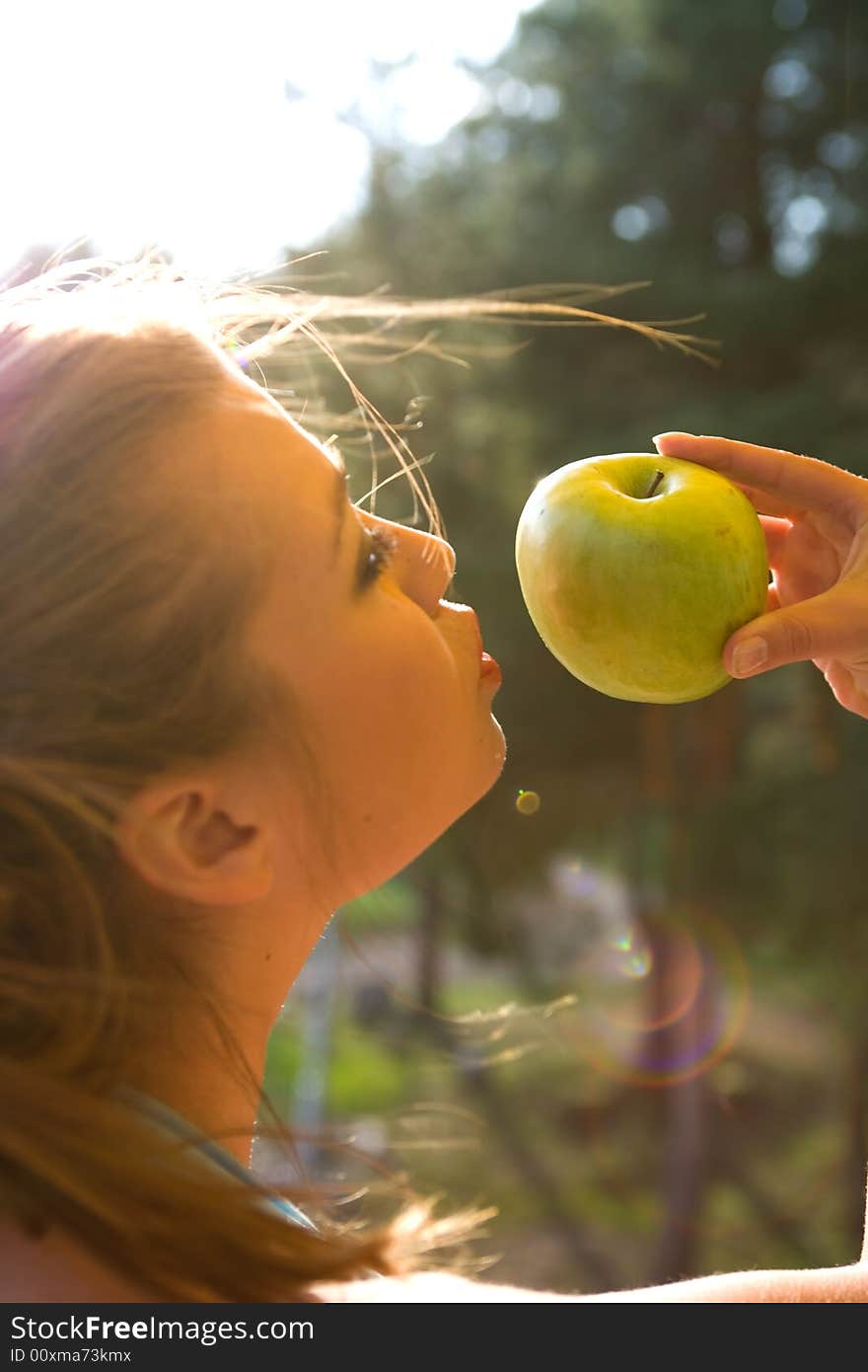 Girl with apple on sunset