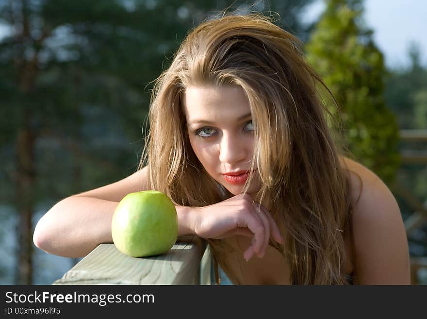 Girl with apple on sunset