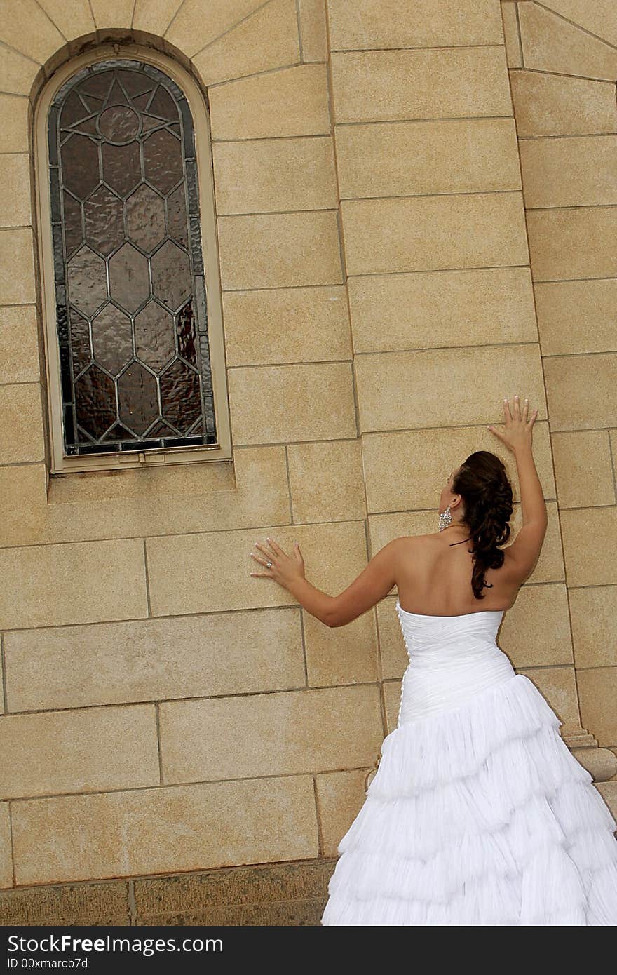 A bride standing next to a chapel. A bride standing next to a chapel