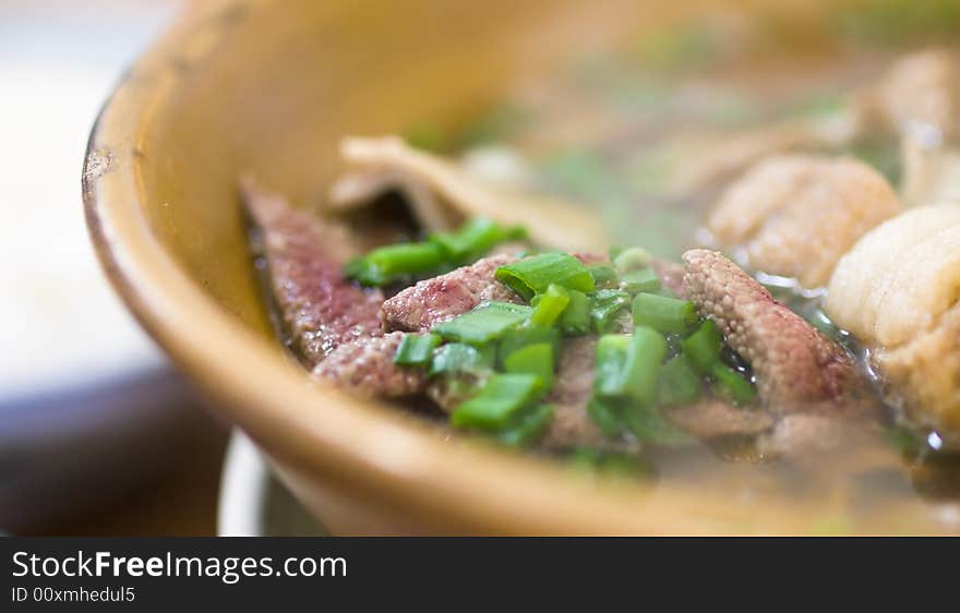 Asian dish of a herbal, tea flavored soup of pork ribs, liver and stomach, garnished with chopped spring onions, served steaming hot, and eaten with plain boiled rice, called bak kut teh in the local language. Asian dish of a herbal, tea flavored soup of pork ribs, liver and stomach, garnished with chopped spring onions, served steaming hot, and eaten with plain boiled rice, called bak kut teh in the local language