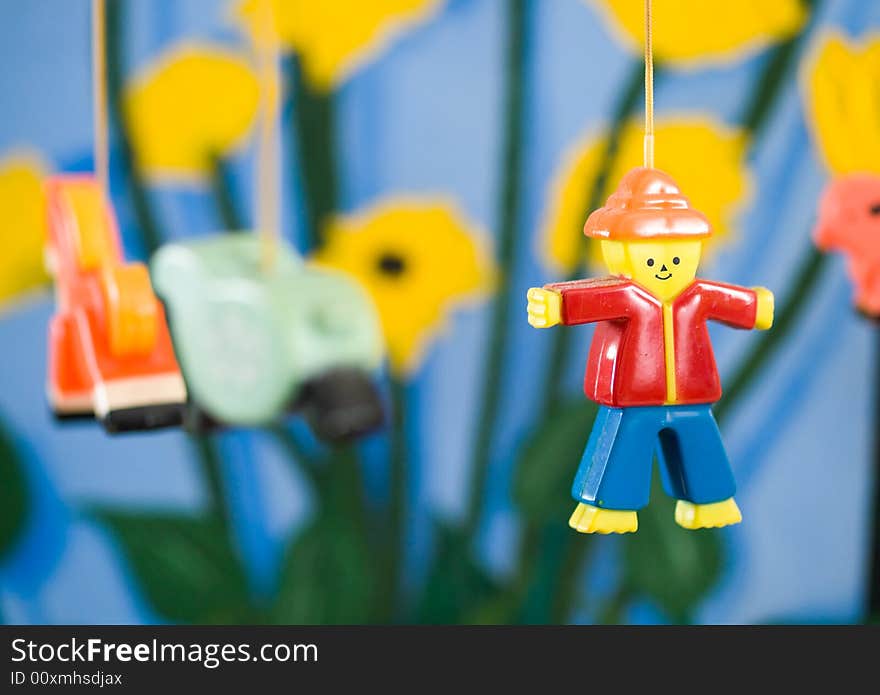 Plastic figurine of a man on a mobile against a colorful painted background. Plastic figurine of a man on a mobile against a colorful painted background