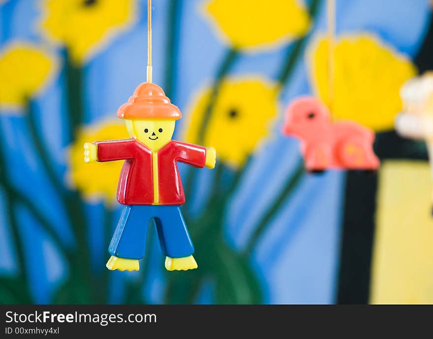 Plastic figurine of a man on a mobile against a colorful painted background. Plastic figurine of a man on a mobile against a colorful painted background