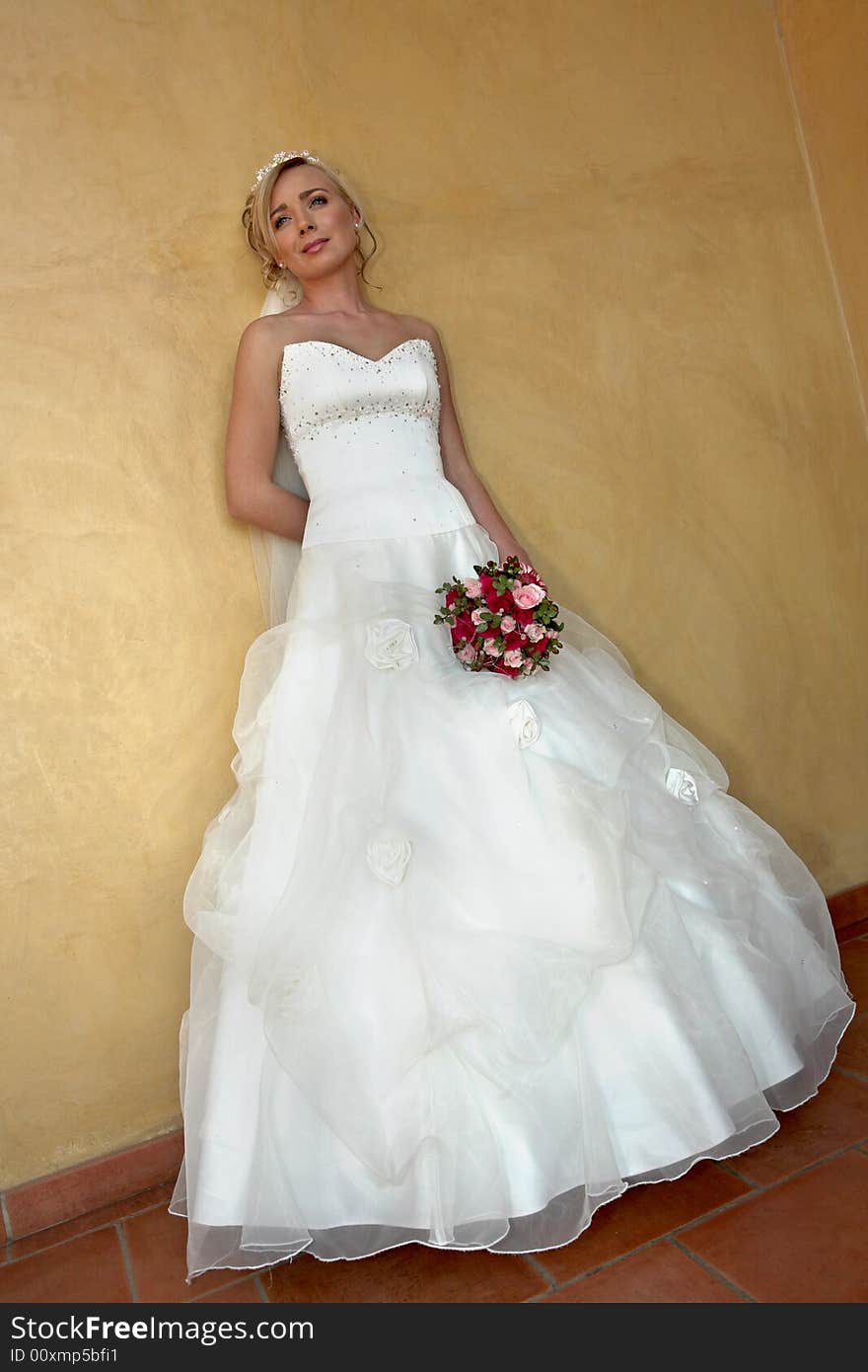 A bride standing against a wall. A bride standing against a wall