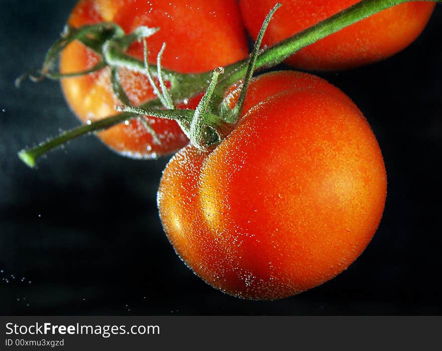 Close up red tomatoes plaсed in a water with air bubbles. Close up red tomatoes plaсed in a water with air bubbles