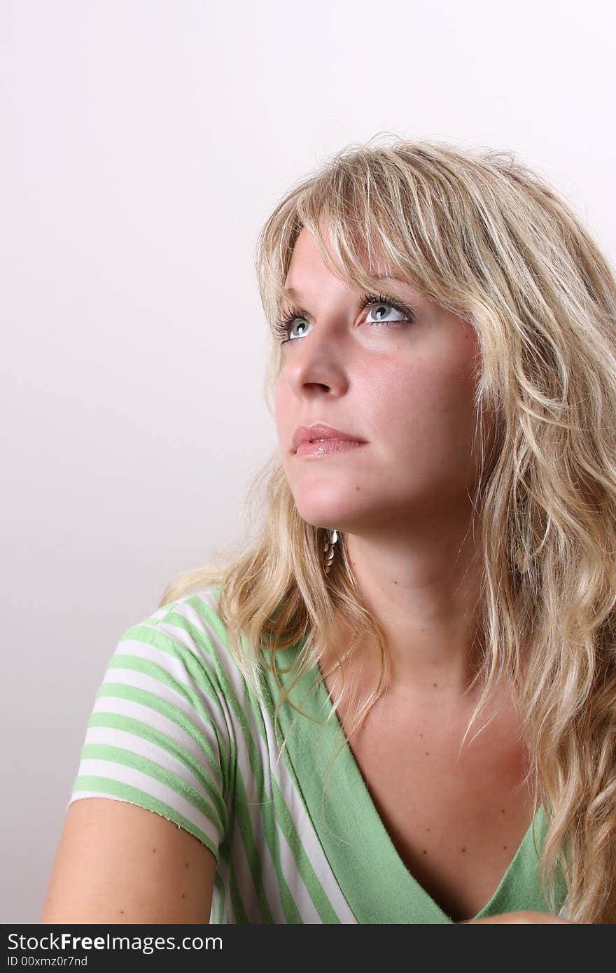 Blond Female model on a white background wearing a green top. Blond Female model on a white background wearing a green top