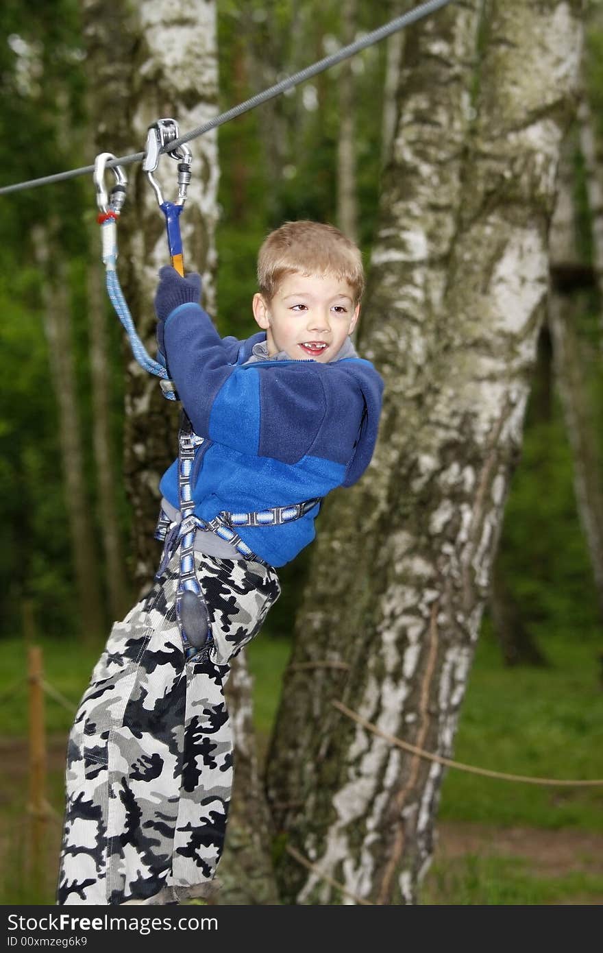 Young boy climbing  in the forest