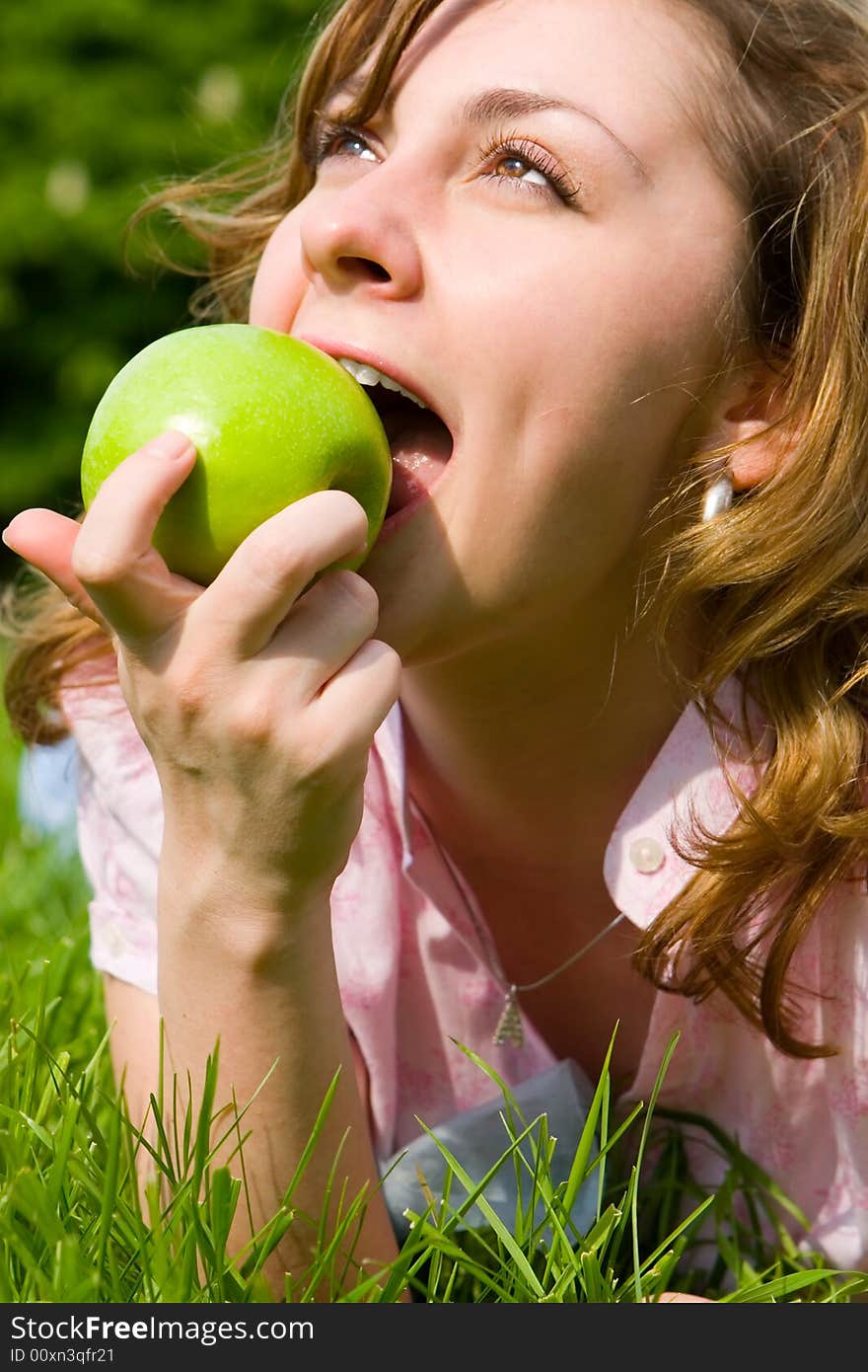 Pretty woman eating green apple