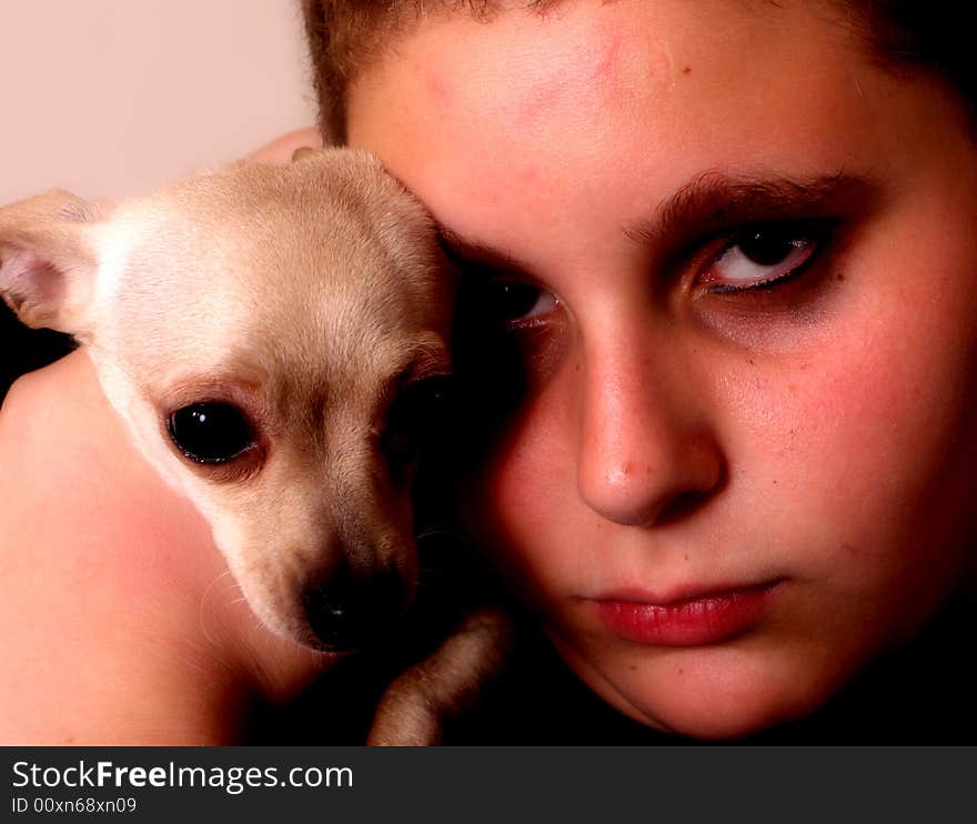 Teenage boy holding his chihuahua near his head. Teenage boy holding his chihuahua near his head.