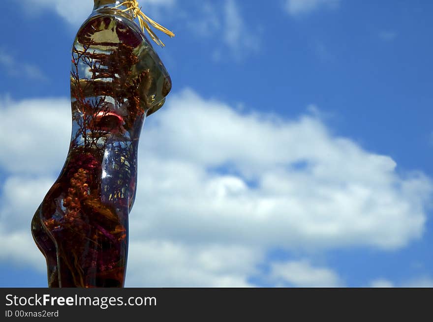 Glass woman with flowers on a background of sky. Glass woman with flowers on a background of sky