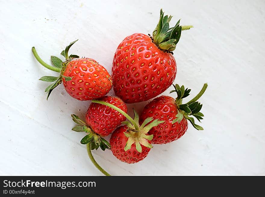 Set of fresh strawberries on white painted board