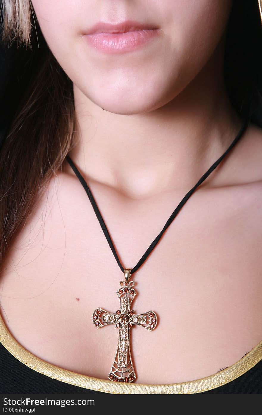 Beautiful precious cross on a breast at the girl