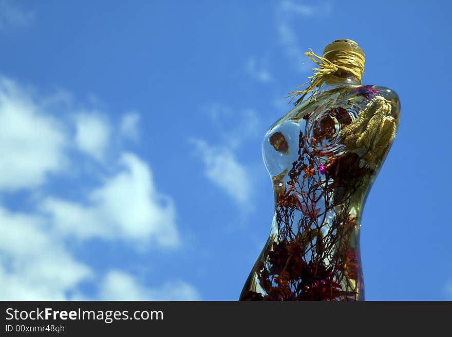 Glass woman with flowers on a background of sky. Glass woman with flowers on a background of sky