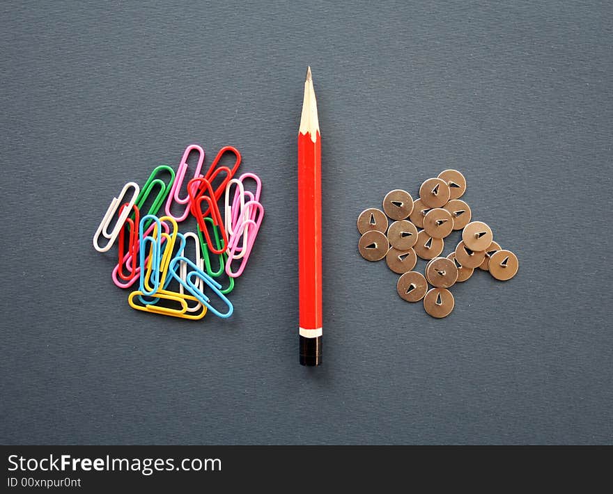 Composition from a pencil, a knife, buttons and multi-coloured paper clips. Composition from a pencil, a knife, buttons and multi-coloured paper clips.