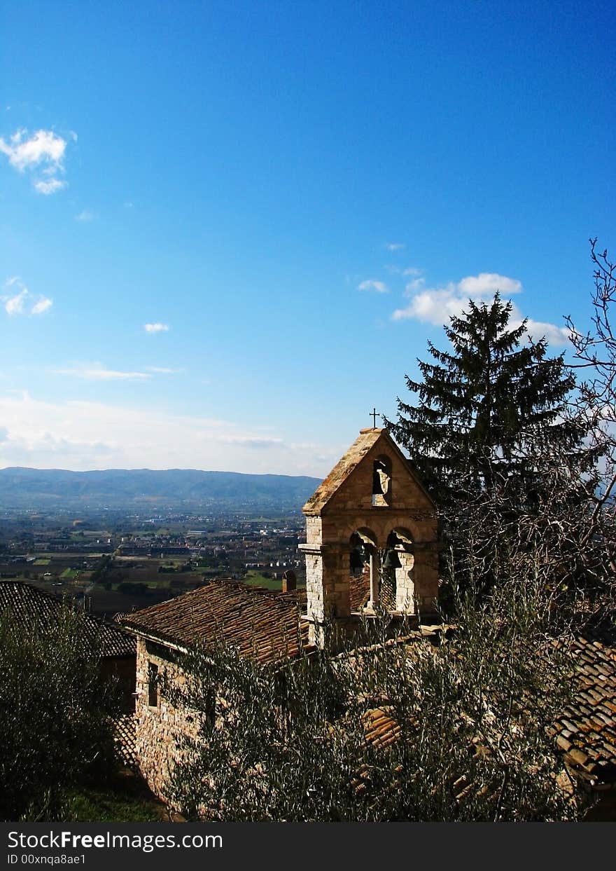 A view of an old church bell tower and the Umbrian countryside in Assisi, Italy. A view of an old church bell tower and the Umbrian countryside in Assisi, Italy.