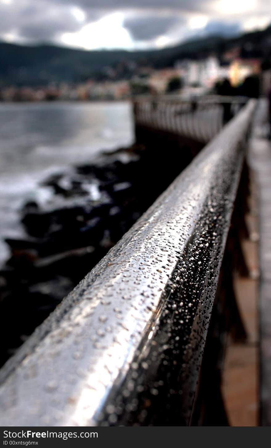 Railing after rain covered with silver drops. the perspective leads to the city. Railing after rain covered with silver drops. the perspective leads to the city